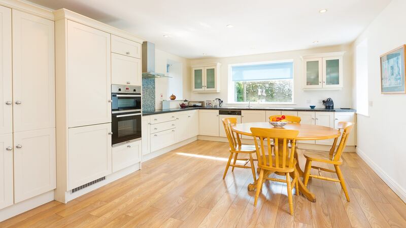 The large, bright kitchen features a semi-solid timber floor and cream units.