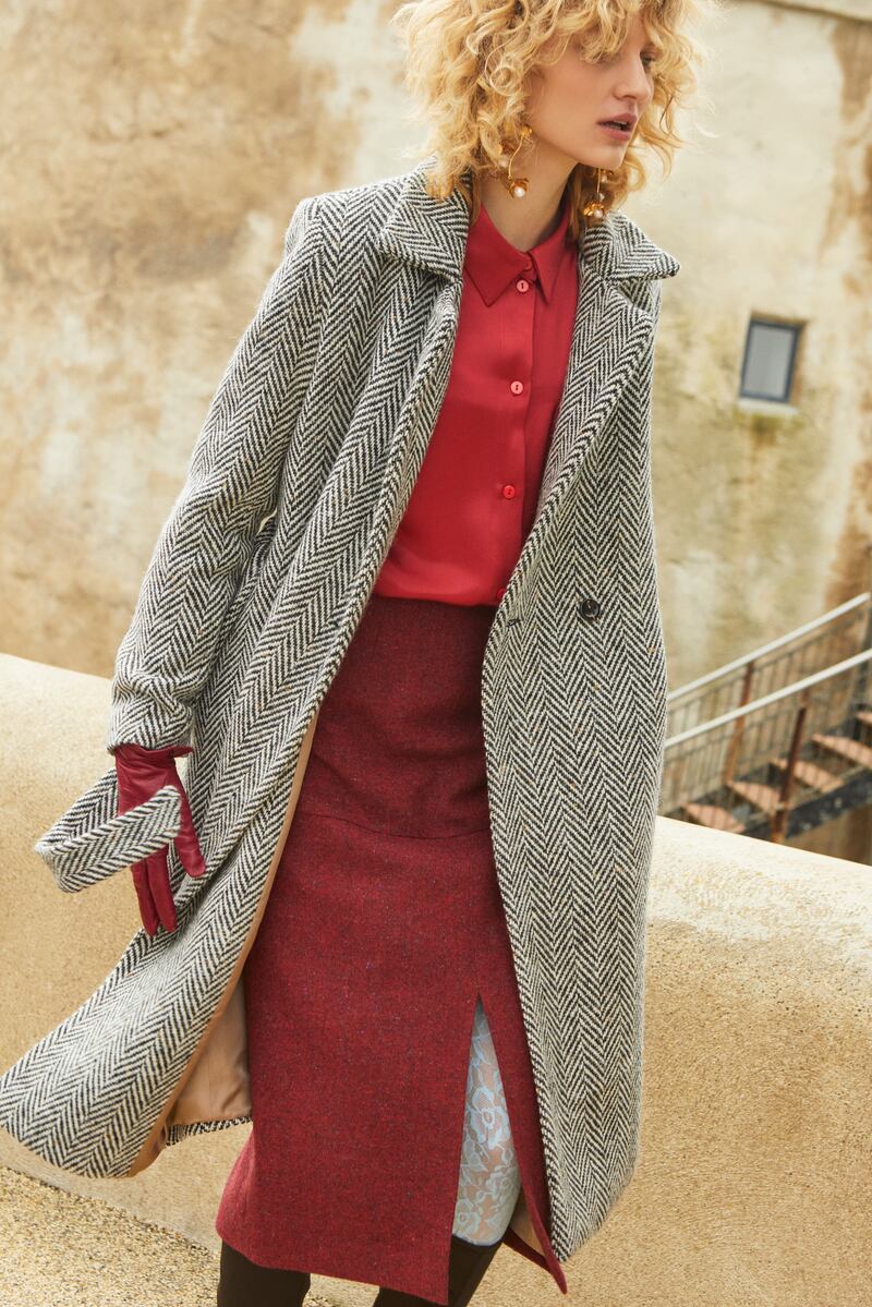 Aoife: Long-sleeved relaxed shirt in radiant red, €285; midi wool fitted split pencil skirt in burgundy, €395; herringbone flecked Donegal tweed wrap coat, €795.