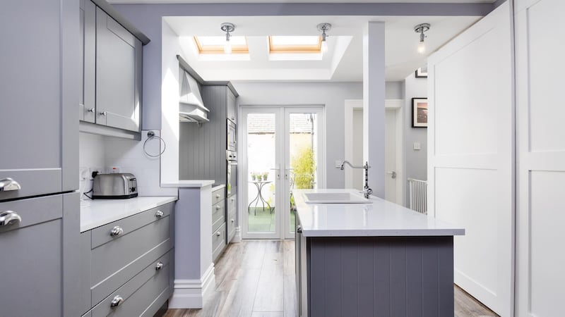 The custom-built kitchen, where a sloped ceiling is lit by a couple of Velux windows, has a French window to the small, enclosed patio