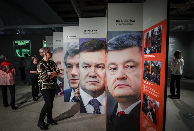 People look at pictures of former Ukrainian presidents (right to left) Petro Poroshenko, Viktor Yushchenko, Viktor Yanukovych and Leonid Kuchma on display at the Manege Central Exhibition Hall in Moscow as part of an exhibition on Russia's 'special military operation' in Ukraine. Photograph: Yuri Kochetkov/EPA-DFE