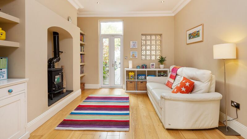 The room to the front has an open fire and double doors leading through to the back room where there is a wood-burning stove, French doors out to the back garden and a glass block detail in the exterior wall