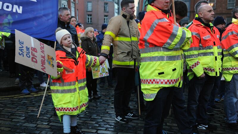 Cassie Crosbie holds her father Terry Crosbie’s hand at a  Dublin Fire Brigade protest outside Dublin City Hall. Photograph: Aidan Crawley