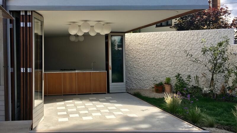The house opens up to become an extension of the garden. Inexpensive light shades are clustered to create an interesting fitting.