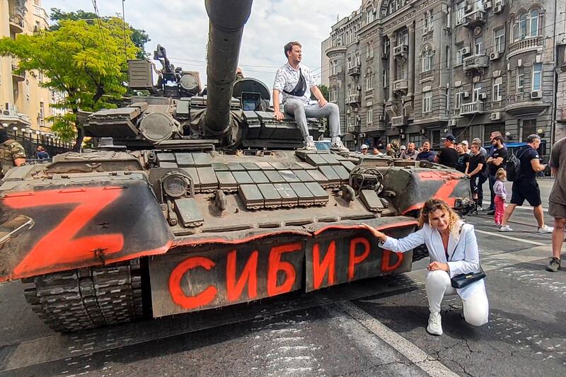A woman poses for a photograph at a Russian armoured vehicle, with writing reading ‘Siberia’, parked in a street in Rostov-on-Don. Photograph: AP