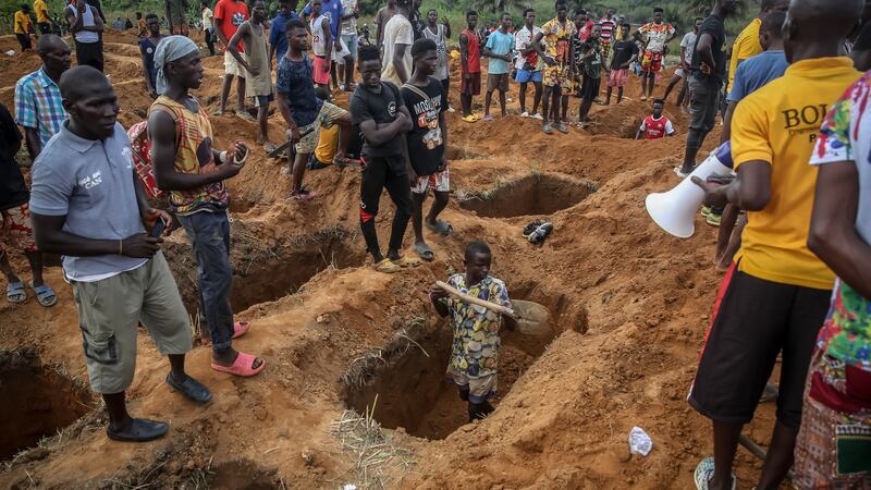 Grave diggers work ahead of a mass burial of Freetown fuel tanker explosion victims on Monday. Photograph: Sally Hayden