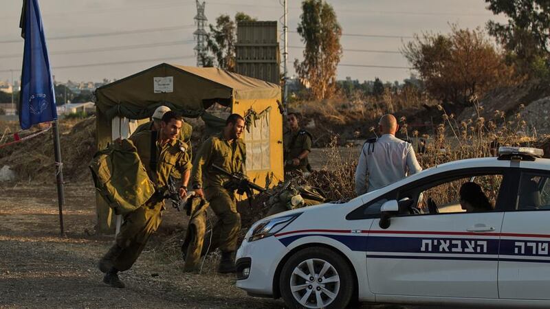 Israeli soldiers run to take cover during an alarm next to an Israeli ‘Iron Dome’ anti-missile defense system installed in the surrounding of Tel Aviv yesterday. Photograph: EPA/Atef Safadi