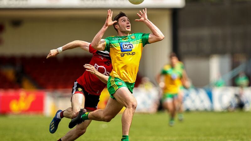 Donegal’s Conor O’Donnell catches the ball with Down’s James McGuinness in pursuit. Photograph: Tommy Dickson/Inpho