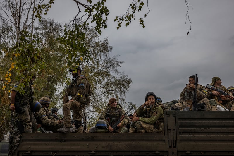 -- EMBARGO: NO ELECTRONIC DISTRIBUTION, WEB POSTING OR STREET SALES BEFORE 12:01 A.M. ET ON FRIDAY, OCT. 7, 2022. NO EXCEPTIONS FOR ANY REASONS -- Members of the volunteer Carpathian Sich battalion prepare to move toward a new position near the town of Lyman, Ukraine, Oct. 2, 2022. Ukrainian soldiers are exulting in their smashing of Russian lines in the northeast, where they engaged enemy troops up close, and gained confidence from it. (Ivor Prickett/The New York Times)