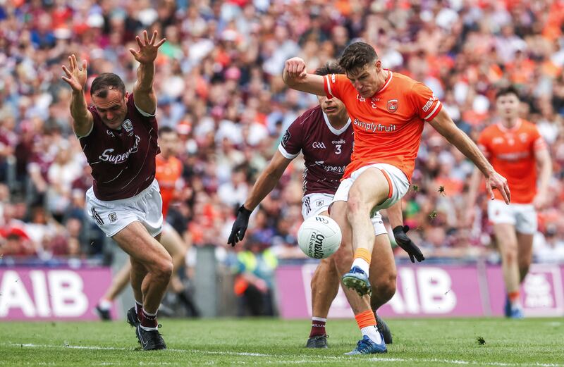 Niall Grimley gets his kick away despite the attempted block from Galway's John Maher. Photograph: Bryan Keane/Inpho 