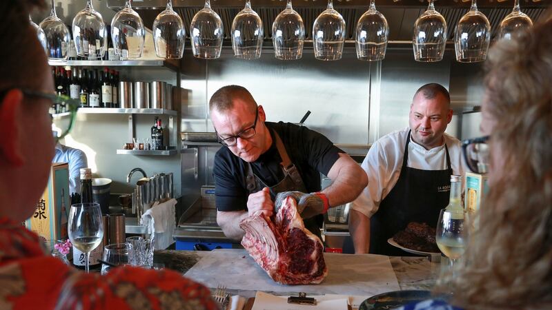 Rick Higgins (left) gets to work on a rib of beef