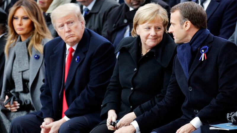 US first lady Melania Trump and US president Donald Trump look on as  German chancellor Angela Merkel talks to French president Emmanuel Macron at the Arc de Triomphe in Paris on November 11, 2018. Photograph:  François Mori