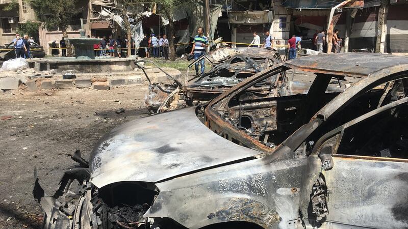 People inspect the damage at the site of a suicide attack in Tahrir Square, in central Damascus. Photograph: Reuters