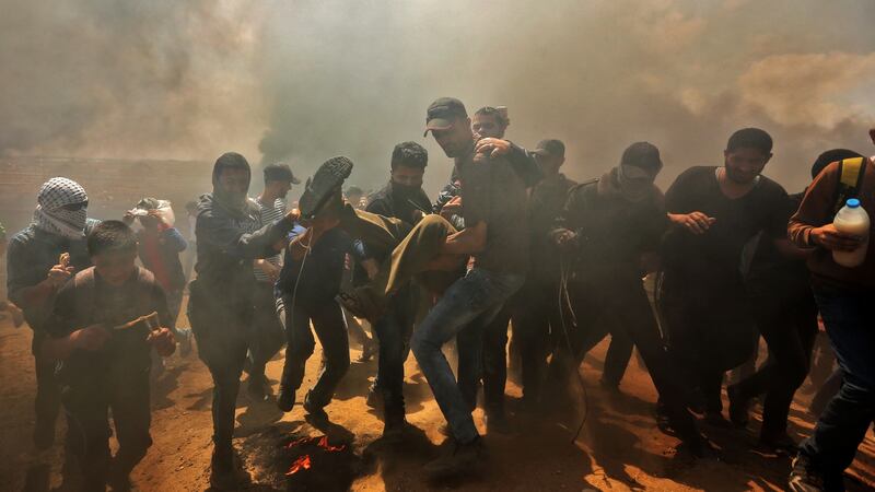 Palestinians carry a demonstrator injured during clashes with Israeli forces near the border between the Gaza Strip and Israel, east of Gaza City, on Monday. Scores were killed. Photograph: Mahmud Hams/AFP/Getty Images
