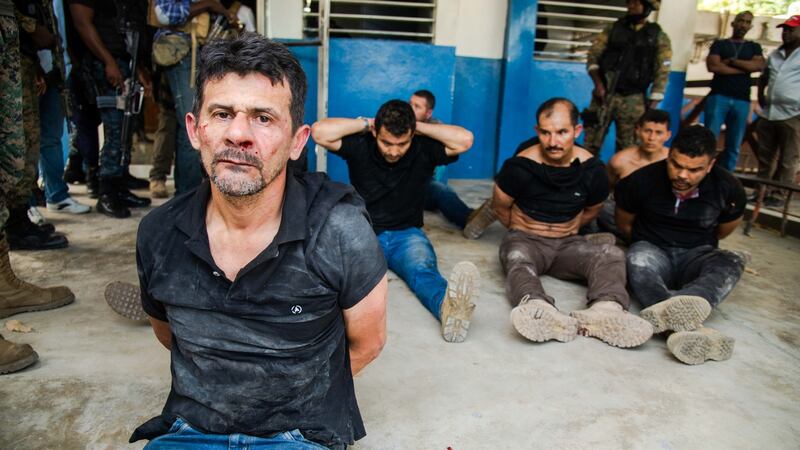 Police officers guard a group of men arrested over the killing of Jovenel Moïse, in Port-au-Prince on Thursday. Photograph: Jean Marc Herve Abelard/EPA