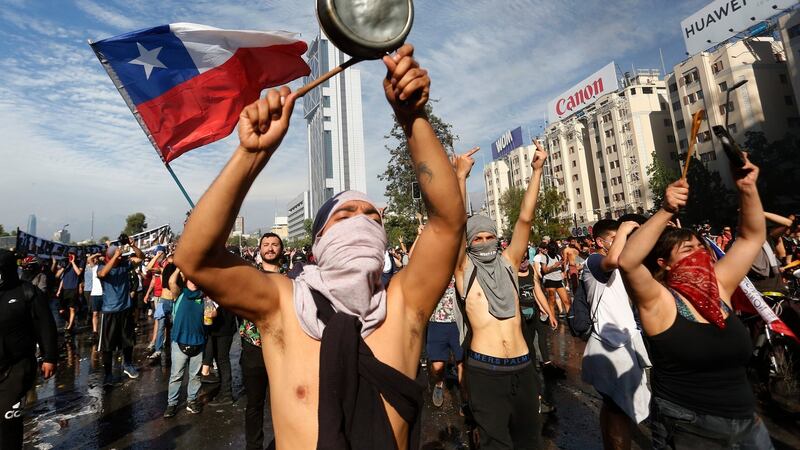 Demonstrators display flags and banners during a protest against Presidente Sebastian Piñera  in Santiago, Chile. Photograph:  Marcelo Hernandez/Getty