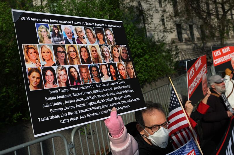 Protesters hold signs as they await the arrival of magazine columnist E Jean Carroll for the first day of her civil trial against former president Donald Trump at a Manhattan Federal Court. Photograph:  Michael M Santiago/Getty Images)