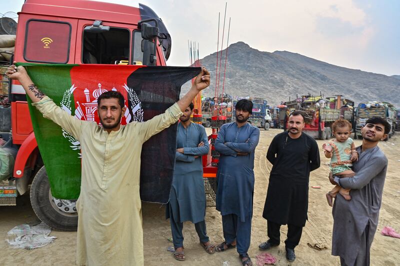 An Afghan refugee holds a national flag as he prepares to depart for Afghanistan. Photograph: Farooq Naeem/AFP/Getty
