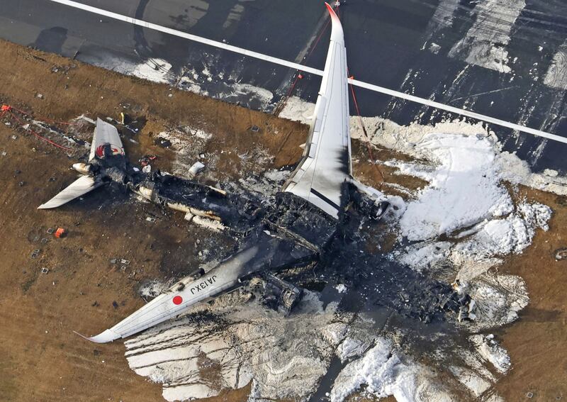 The aftermath of the burnt-out plane in Tokyo. Photograph: Kyodo News/AP