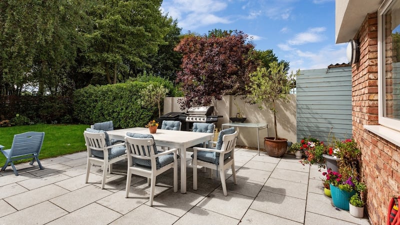 The paved patio  and  garden to the rear of the house