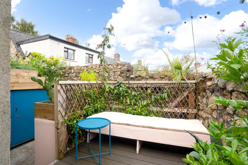 The back yard consists of an elevated decking, with a built-in bench, and a lower yard space. 