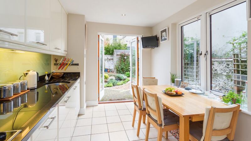 The fitted kitchen/breakfastroom, where colours are cream, black and aqua, has French windows to the garden