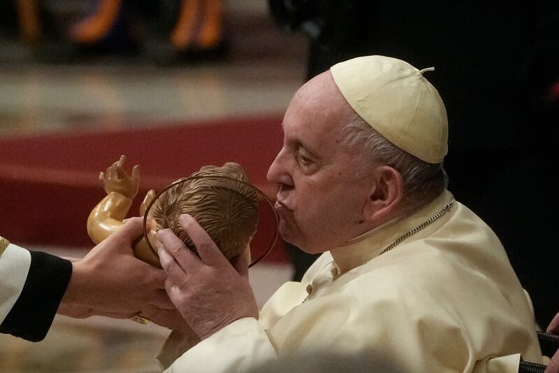 Pope Francis kisses a statue of  Jesus as he presides over Christmas Eve Mass, at St Peter’s Basilica at the Vatican. Photograph: Gregorio Borgia/AP/PA