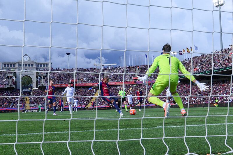 Barcelona's Raphinha scores a goal against Madrid goalkeeper Thibaut Courtois. Photograph: Lluis Gene/AFP via Getty Images   