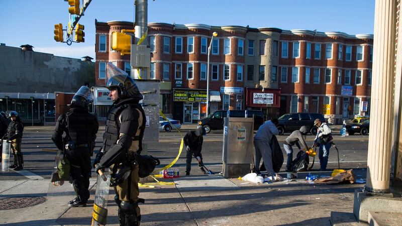 Maryland state troopers stand guard in April 2015 as residents clean up after an evening of riots following the funeral of Freddie Gray  in Baltimore. Photograph: Evan Vucci/AP