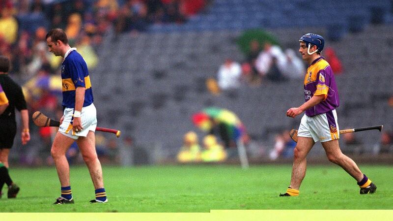 Brian O’Meara of Tipp and Liam Dunne of Wexford leave the field after being sent off by referee Pat Horan. Photograph: Patrick Bolger/Inpho