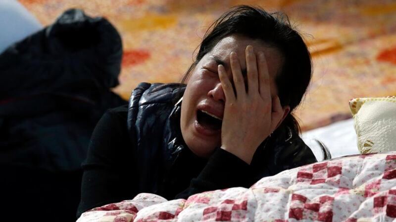 A family member of a missing passenger onboard the Sewol ferry which capsized on Wednesday, cries as she checks the newly announced list of the dead, at a gym in Jindo today. Photograph: Reuters