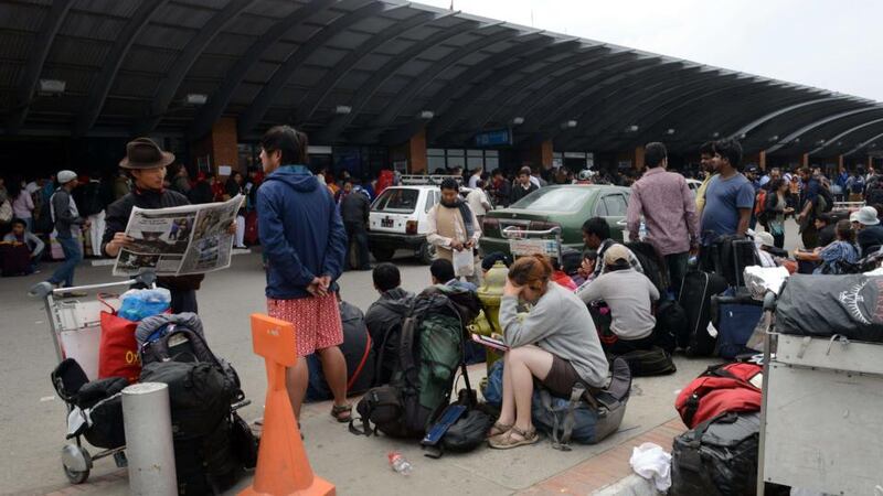 Travellers wait outside the departure hall of the airport in Kathmandu on April 26th  as they wait to leave the Nepalese capital following a 7.9 earthquake which struck the Himalayan nation on Saturday. Photograph: Prakash Mathema/AFP/Getty Images.