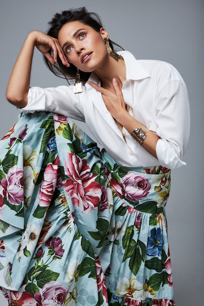 White shirt € 225 Vince, floral full skirt € 995 Dolce + Gabbana, gold cuff € 325 and gold drop earrings€ 270 both MaxMara, flat leather sandals € 490 Celine