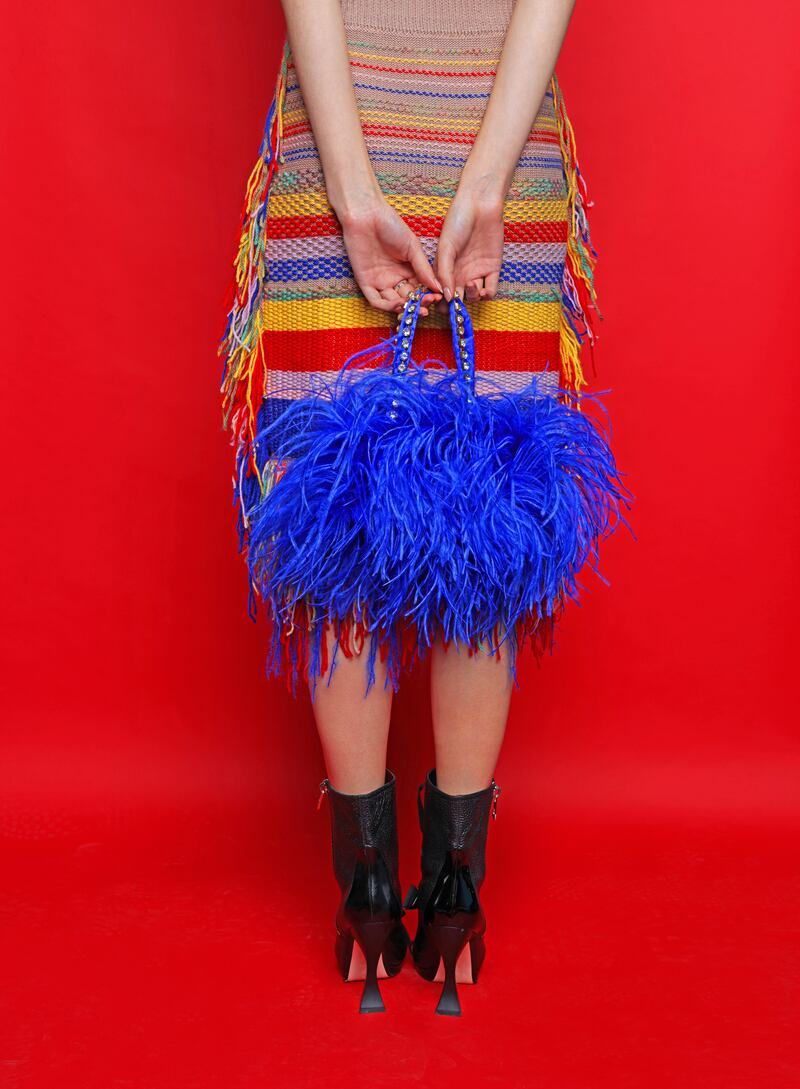 Multicoloured fringe skirt by Lily Pilgrim, @lily.pilgrim.knitwear; blue tights from Tights Dept; black Victorian-style boots by Loewe; and blue ostrich feather bag by Sorcha Ó Raghallaigh
Multi colourexd ring Rothlu from The Collective