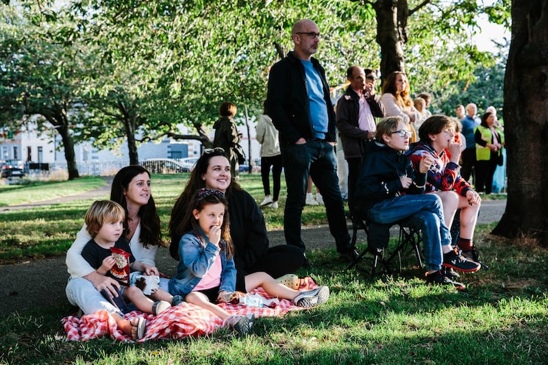 From the left Adam, Ciara and Emmie Bolger-Lawson and Sinead Murphy together with local residents of the Tenters, Dublin 8, watching the screening of new documentary promoting the housing scheme, in Oscar Square. Photograph Tiberio Ventura / The Irish Times