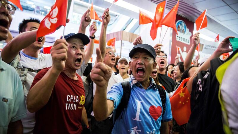 Pro-China supporters sing the national anthem inside a shopping mall in the Kowloon Bay district of Hong Kong on Saturday. Photograph: Isaac Lawrence/AFP/Getty Images.