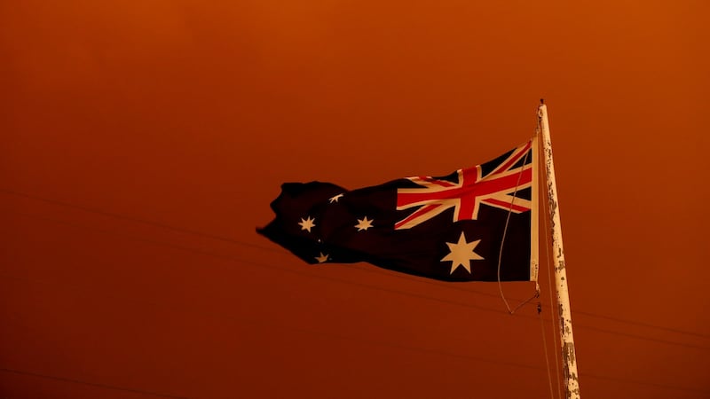 The Australia Flag flies under red skies in Bruthen, Victoria.  Photograph: Darrian Traynor/Getty