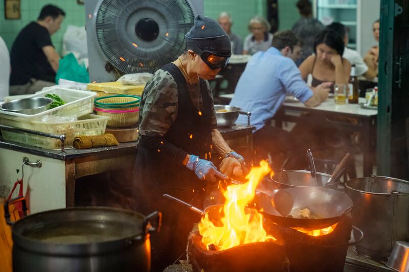 The owner of Raan Jay Fai, which was awarded a Michelin star in 2018, cooks in a kitchen set up by a street at night. Photograph: Kokkai Ng/iStock/Getty