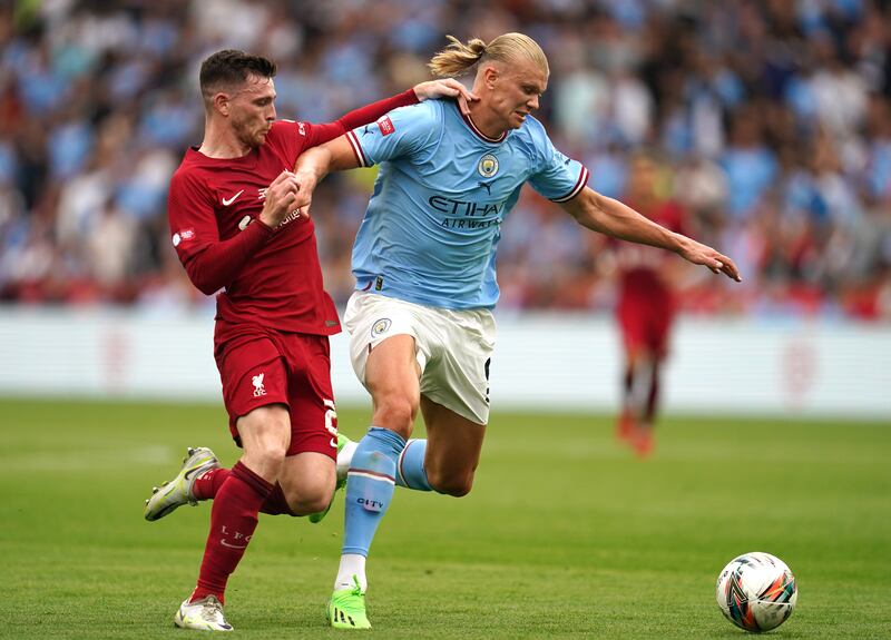 Manchester City's Erling Haaland holds off Liverpool defender Andrew Robertson at the King Power Stadium. Photograph: PA