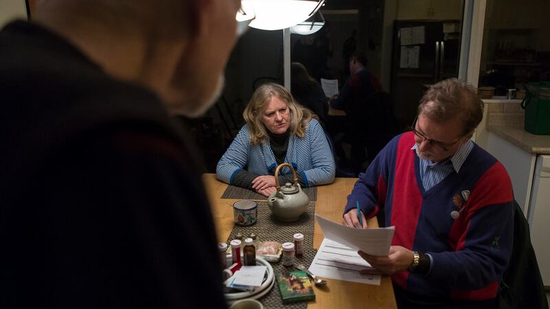 John Shields and his wife, Robin June Hood, watch as Dr. David Massel signs forms confirming that Shields qualified for a medically assisted death. Photograph: Leslye Davis/The New York Times
