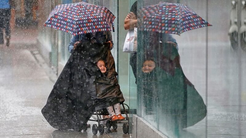 People seek cover amid the heavy showers in Dublin on Tuesday afternoon. Photograph: Nick Bradshaw/The Irish Times