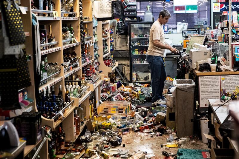 An employee stands behind the counter amid fallen bottles that smashed on the ground after an earthquake, at a gas station and liquor store in Ridgecrest, California on Saturday. Photograph: Etienne Laurent/EPA