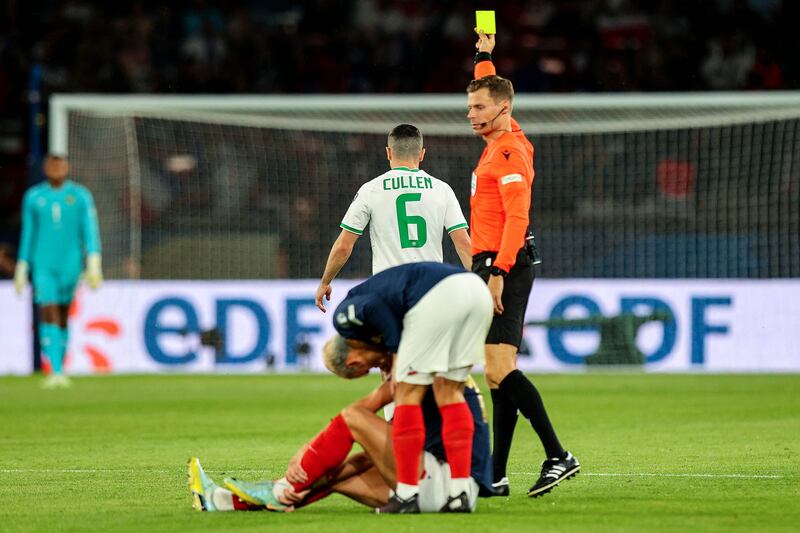Josh Cullen is shown a yellow card by referee Urs Schnyder. Photograph: Ryan Byrne/Inpho