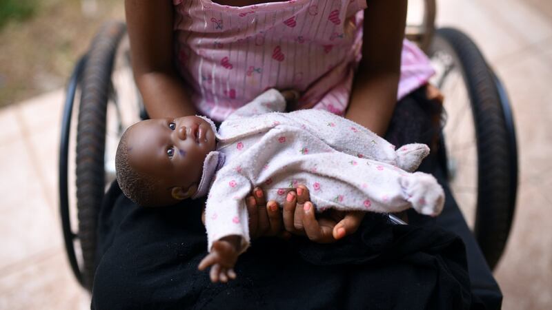 A five-year-old girl poses with her doll as she sits in her wheelchair in the courtyard of the Aberdeen Women’s Center, one year after a sexual assault that her family says left her paralysed, in Freetown, Sierra Leone. Photograph: Cooper Inveen/Reuters