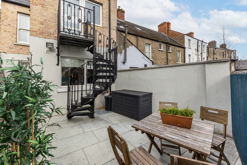 Back garden with Victorian spiral staircase leading down from the kitchen