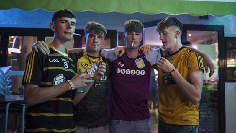 Santa Ponsa and Magaluf: Irish lads who want their photograph taken outside the Sinners Rest bar; all pose with cigarettes, “whether they want one or not”. Photograph: Tomeu Coll