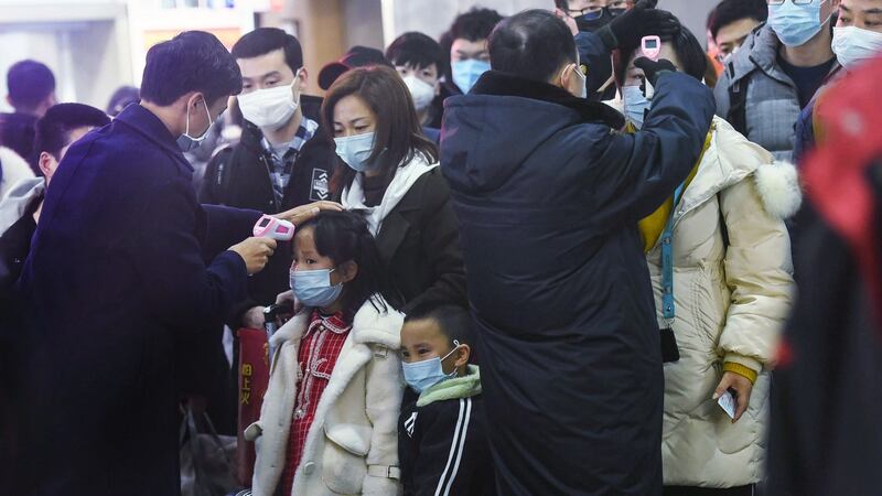 Staff members  check the body temperature of passengers after a train from Wuhan arrived at Hangzhou Railway Station in Hangzhou, China’s eastern Zhejiang province, on January 23rd. Photograph: STR/AFP via Getty Images