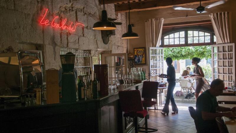 Le Galoubet evokes both the Middle Ages (stone walls, beamed ceilings, massive hearth) and the mid-20th century (industrial lamps, red neon sign). Photograph: Stefano Buonamici for The New York Times