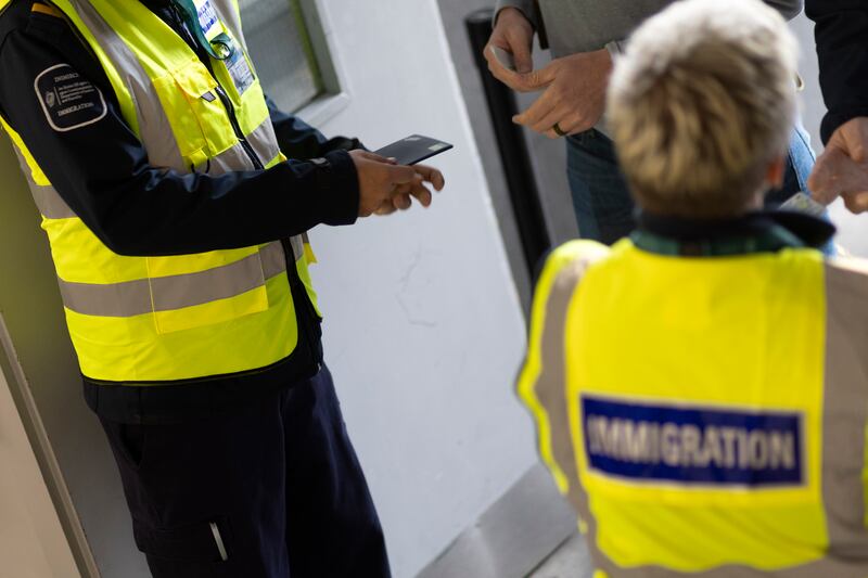 Border Management Unit immigration officials checking travel documents as people arrive at the gate at Dublin airport. Photograph: Chris Maddaloni