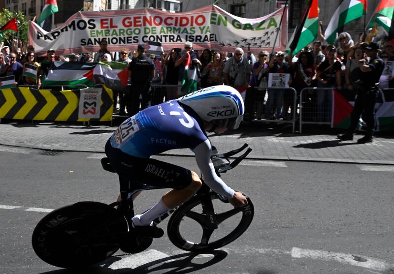 Protesters wave Palestinian flags as Israel Premier Tech's rider Nadav Raisberg competes during the Vuelta. Photograph: Miguel Riopa/AFP via Getty Images        