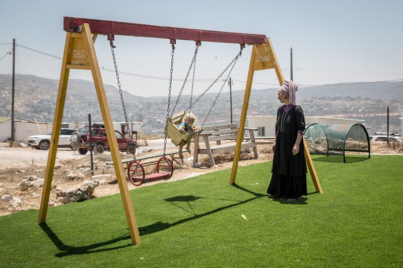 Israeli settler Techiya Chaim swings one of her children in the Evyatar outpost. Photograph: Sally Hayden